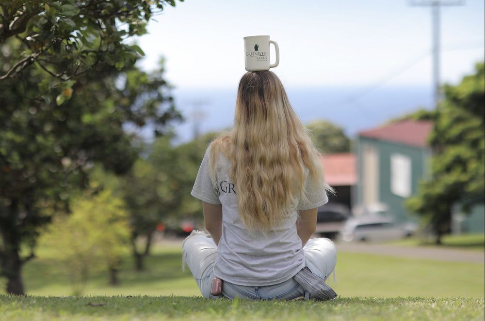 Woman with Kona Coffee Cup on her head contemplating the health benefits it might have